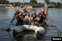 Waokoaji wakiwaondoa watu katika eneo la mafuriko baada ya bwawa la Nova Kakhovka kulipuliwa, huko Kherson, Ukraine, Juni 7, 2023.