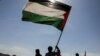 FILE — Houthi followers hold a Palestinian flag in solidarity with the Palestinians and to show support to Houthi strikes on ships in the Red Sea and the Gulf of Aden, in Sanaa, Yemen, Jan. 29, 2024. The U.S. reinstated sanctions on Yemen's Houthi rebels Friday.