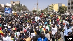 Civil society groups and political groups hold placards as they march calling on authorities to respect the election date, in Dakar, on February 17, 2024. 