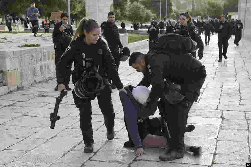 Israeli police arrest a Palestinian woman at the Al-Aqsa Mosque compound following a raid at the site in the Old City of Jerusalem during the Muslim holy month of Ramadan. Palestinian media reported police attacked Palestinian worshippers, raising fears of wider tension as Islamic and Jewish holidays overlap.