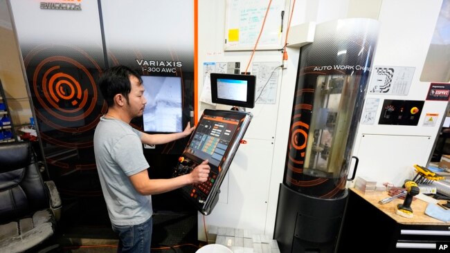 A worker at Reata Engineering and Machine Works programs a Mazak Variaxis machine used to make semiconductor pieces, Feb. 15, 2024, in Englewood, Colo. Reata has invested heavily in software that automates its manufacturing processes.