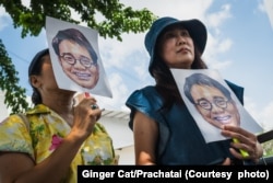 Sitanun Satsaksit (right), a sister of Wanchalearm Satsaksit, a Thai activist who was abducted in 2020 while living in self-imposed exile in Phnom Penh, holds her brother's image as she was demonstrating on 21 February 2024.