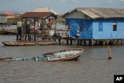 A partially submerged boat is seen at the coastal area of Ayetoro, in Southwest Nigeria, Thursday, April 4, 2024. (AP Photo/Dan Ikpoyi)