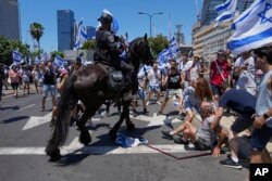 Israeli police disperse demonstrators blocking a road during a protest against plans by Prime Minister Benjamin Netanyahu's new government to overhaul the judicial system, in Tel Aviv, July 11, 2023.