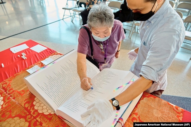 FILE - In this photo provided by the Japanese American National Museum, Barbara Keimi stamps the Ireichō at the Japanese American National Museum in Los Angeles, Sept. 24, 2022. T