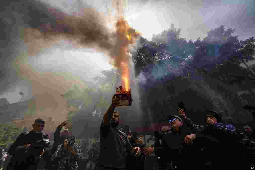 A protester launches fireworks at the Lebanese Central Bank building as frustrated depositors rally against Central Bank Gov. Riad Salameh, who is facing corruption charges, and the deepening financial crisis in Beirut, Lebanon.