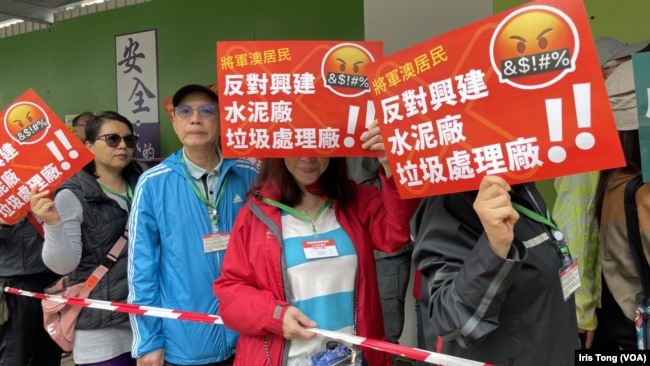 今年3月26日举行的“将军澳反填海游行”，是香港经历3年疫情后首次有社会议题的游行，数以百计参加者必须在封锁线范围内挂上印有编号的“颈牌”游行。 （美国之音/汤惠芸）