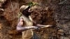 FILE - A miner digs out soil that will be filtered for traces of cassiterite, the major ore of tin, at a mine in eastern Congo, on Aug. 17, 2012. Violence has plagued the mineral-rich region, resulting in a suspension of mining ordered on July 19, 2024.