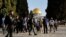 Sejumlah pasukan keamanan Israel terlihat berjalan di samping para pengunjung di Masjid Al-Aqsa, di Yerusalem, pada 5 April 2023. (Foto: Reuters/Ammar Awad)