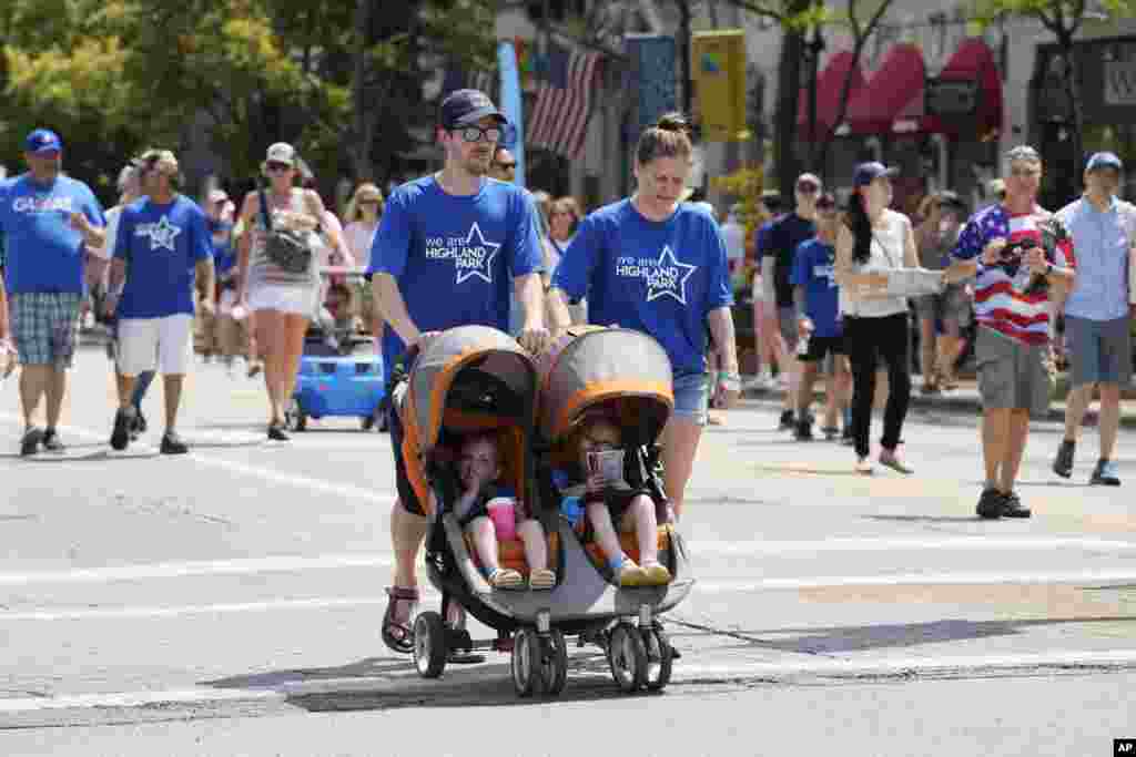 People participate in a community walk in Highland Park, Ill., on July 4, 2023, a year after a shooter killed seven people at the city's annual parade. The walk replaced the parade, and the city also held a remembrance service. 