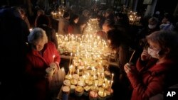 FILE - Para jamaah mengumpulkan madu mereka setelah misa untuk diberkati di gereja Perawan Maria Terberkati di kota Blagoevgrad, sekitar 100 kilometer selatan ibu kota Bulgaria, Sofia, Rabu, 10 Februari 2021. (AP/Valentina Petrova)