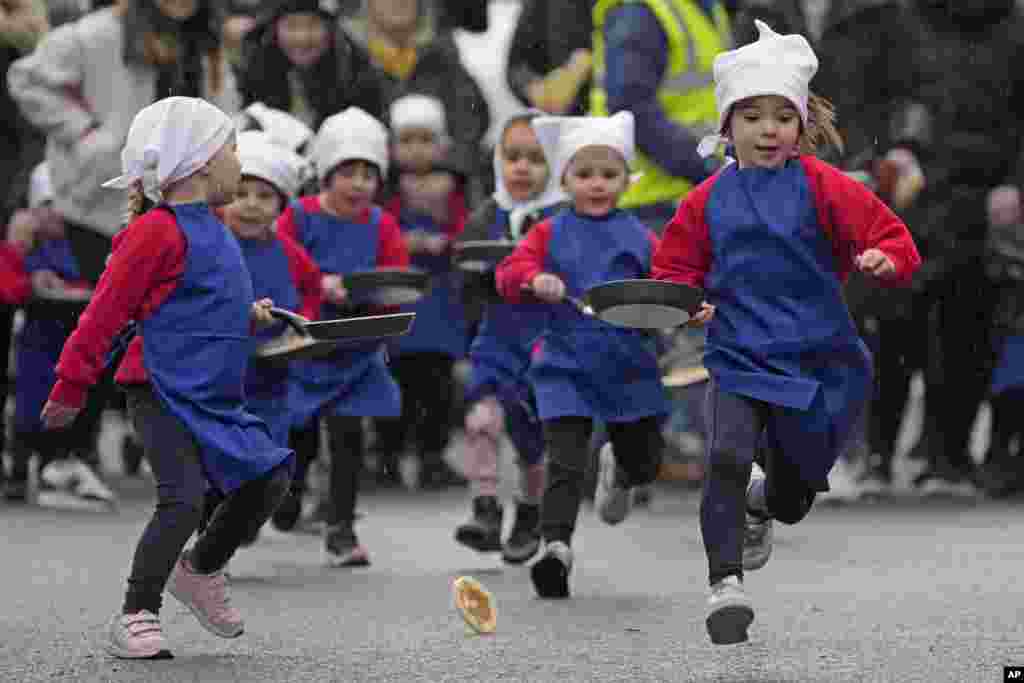 Schoolchildren from local schools take part in the children&#39;s races prior to the yearly pancake race in the town of Olney, in Buckinghamshire, England.