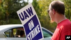 Striking United Auto Workers member David Martin holds a sign outside the General Motors Customer Care and After-Sales facility in Brandon, Miss., Sept. 22, 2023. Unionized workers joined others in new nationwide walkouts as the labor standoff continued.