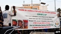 FILE - Supporters of the Alliance of Sahel States (AES) hold up a banner as they celebrate Mali, Burkina Faso and Niger leaving the Economic Community of West African States (ECOWAS), in Niamey, Niger, Jan. 28, 2024. 