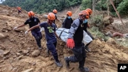 Rescuers carry a body they recovered at the landslide-hit village of Masara in Davao de Oro province, southern Philippines, Feb. 9, 2024. (Municipality of Monkayo via AP)