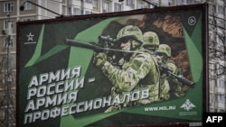 FILE - A photograph taken Oct. 24, 2022, shows a recruitment poster displaying Russian soldiers with a slogan reading 'Army of Russia - Army of professionals' as seen on a street in Moscow. 