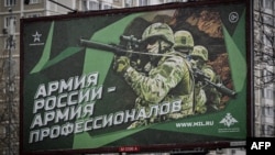 FILE - A photograph taken Oct. 24, 2022, in Moscow shows a poster displaying Russian soldiers with a slogan reading "Russia's Army is an Army of Professionals."