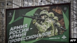 FILE - A photograph taken Oct. 24, 2022 shows a poster displaying Russian soldiers with a slogan reading 'Army of Russia - Army of professionals' decorating a street in Moscow.
