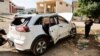 Los palestinos inspeccionan un automóvil atacado por las fuerzas israelíes durante una redada en la que mataron a un militante palestino, cerca de Tubas, en la Cisjordania ocupada por Israel, el 12 de abril de 2024.