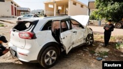 Los palestinos inspeccionan un automóvil atacado por las fuerzas israelíes durante una redada en la que mataron a un militante palestino, cerca de Tubas, en la Cisjordania ocupada por Israel, el 12 de abril de 2024.