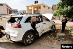 Palestinians inspect a car targeted by Israeli forces during a raid where they killed a Palestinian militant, near Tubas, in the Israeli-occupied West Bank, April 12, 2024.