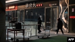 大衆走過北京一處商業區關閉的餐廳。 （2024年1月29日）