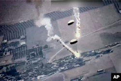 In this image from video released by the U.S. Air Force, parachute flares, that according to the U.S. Air Force, released by a Russian SU-35 are visible near a U.S. Air Force MQ-9 Reaper drone on July 5, 2023, over Syria.