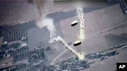 In this image from video released by the U.S. Air Force, parachute flares, that according to the U.S. Air Force, released by a Russian SU-35 are visible near a U.S. Air Force MQ-9 Reaper drone on July 5, 2023, over Syria.