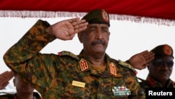 FILE — Sudan's General Abdel Fattah al-Burhan salutes as he listens to the national anthem after landing in the military airport of Port Sudan, Sudan, August 27, 2023.