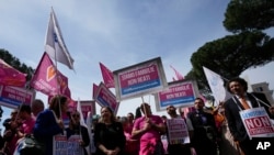 People hold banners reading 'We are families not crimes' during a pro-surrogacy flash-mob in Rome, April 5, 2024.