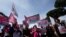 People hold banners reading 'We are families not crimes' during a pro-surrogacy flash-mob in Rome, April 5, 2024.