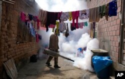 FILE - A health worker fumigates to help mitigate the spread of dengue at a home in Caranavi, Bolivia, March 2, 2023.