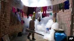 FILE - A health worker fumigates to help mitigate the spread of dengue at a home in Caranavi, Bolivia, March 2, 2023. 