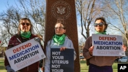 FILE - Three members of the Women's March group protest in support of access to abortion medication outside the Federal Courthouse, March 15, 2023 in Amarillo, Texas. 