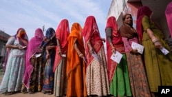 FILE - Women stand in a queue to cast their votes in Chachiyawas village, near Ajmer, India, Nov. 25, 2023.