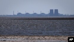 The Zaporizhzhia nuclear power plant is seen in the background of the shallow Kakhovka Reservoir after the dam collapse, in Energodar, Russian-occupied Ukraine, June 9, 2023.