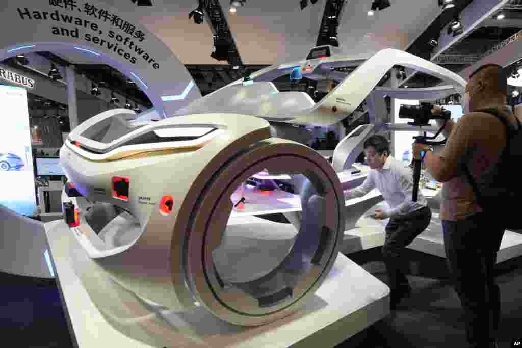 Attendees look at a display showing the parts of an intelligent vehicle during Auto Shanghai 2023 show in Shanghai, China.