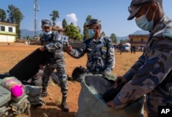 Polisi mengemas bahan bantuan untuk dibagikan kepada para penyintas gempa di Distrik Jajarkot, barat laut Nepal, Senin, 6 November 2023. (AP/Niranjan Shrestha)