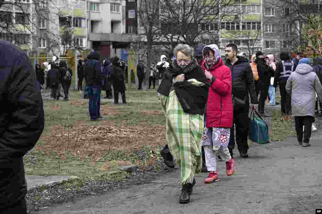 Місцеві мешканці у подвірʼї&nbsp;пошкодженого багатоповерхового будинку внаслідок російської атаки на Київ.&nbsp;Фото&nbsp;AP/&nbsp;Єфрем Лукацький,&nbsp;7 лютого, 2024 року