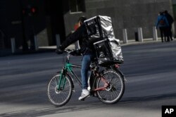 Seorang pria mengendarai sepeda elektronik di New York untuk pengiriman barang, 21 Desember 2017. Rencana untuk mengintensifkan tindakan keras terhadap sepeda listrik memicu kekhawatiran di kalangan para pekerja pengiriman barang yang sebagian besar imigran di Kota New York. (AP/Seth Wenig)