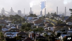 FILE - Smoke billows out of a chimney stack of steel works factories in Port Kembla, south of Sydney, Australia, July 2, 2014.