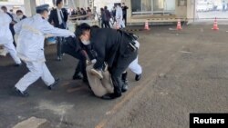 Law enforcement personnel hold down a person after an explosion was heard near Japanese Prime Minister Fumio Kishida delivering an outdoor speech, in Saikazaki, Japan, April 15, 2023, in this screen grab from video. (Twitter @Ak2364N/via Reuters) 