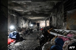 This picture shows burned motorbikes and the damage on the ground floor of a 10-storey building after a major fire at an apartment block in Hanoi, Sept. 13, 2023.