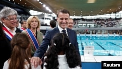 法国总统马克龙视察巴黎附近为2024巴黎奥运会新建造的水上运动中心时与孩子们互动。（2024年4月4日）