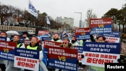 Doctors and Medical workers take part in a protest against a plan to admit more students to medical school, in front of the Presidential Office in Seoul, South Korea, Feb. 21, 2024. 