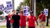UAW union members picket on the street in front of a Stellantis distribution center, Sept. 25, 2023, in Carrollton, Texas. 