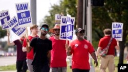 UAW union members picket on the street in front of a Stellantis distribution center, Sept. 25, 2023, in Carrollton, Texas. 