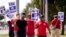 UAW union members picket on the street in front of a Stellantis distribution center, Sept. 25, 2023, in Carrollton, Texas. 
