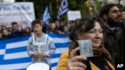 Një pjesëmarrëse mban në dorë një ikonë gjatë protestave në Greqi kundër projektligjit për martesat e së njëjtës gjini