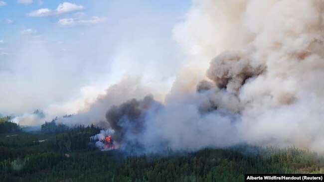FILE — Smoke rises above the southeast perimeter of the Paskwa fire near Fox Lake, Alberta, Canada, May 16, 2023. Seventeen wildfires have broken out in Alberta in 2024; 52 have been burning since last year. (Alberta Wildfire/Handout via Reuters)